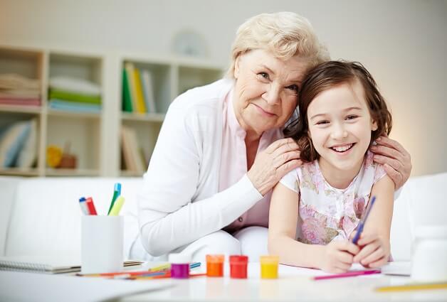 Babcia z wnuczką malującą farbami