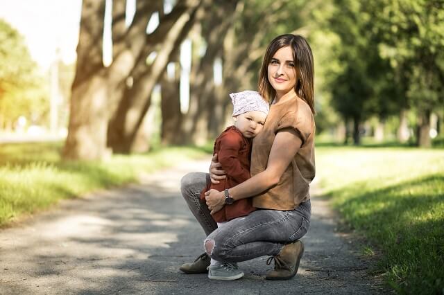 Mama przytulająca dziecko w parku