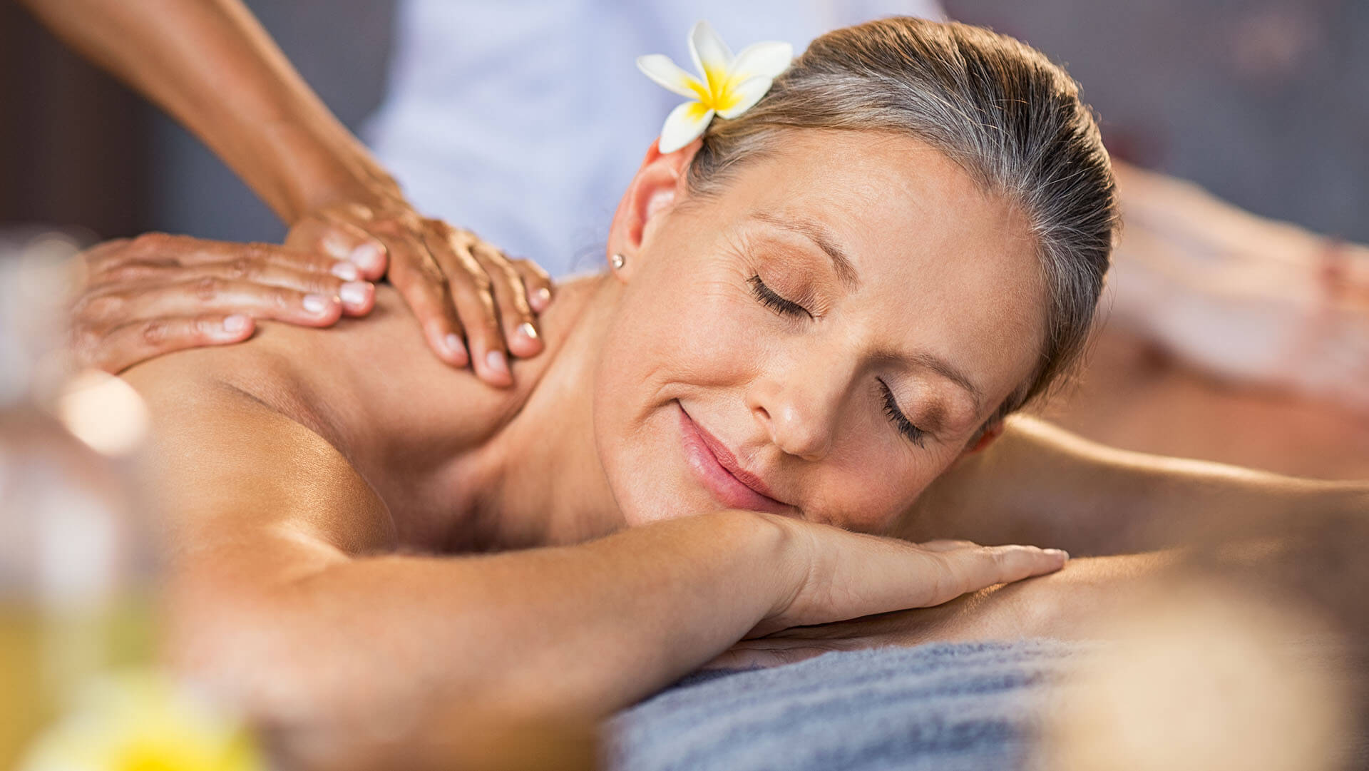 Starsza kobieta relaksująca się podczas masażu w spa