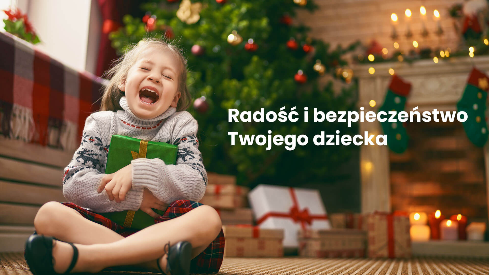 Kilkuletnia dziewczynka siedząca pod choinką, ciesząca się z prezentu świątecznego