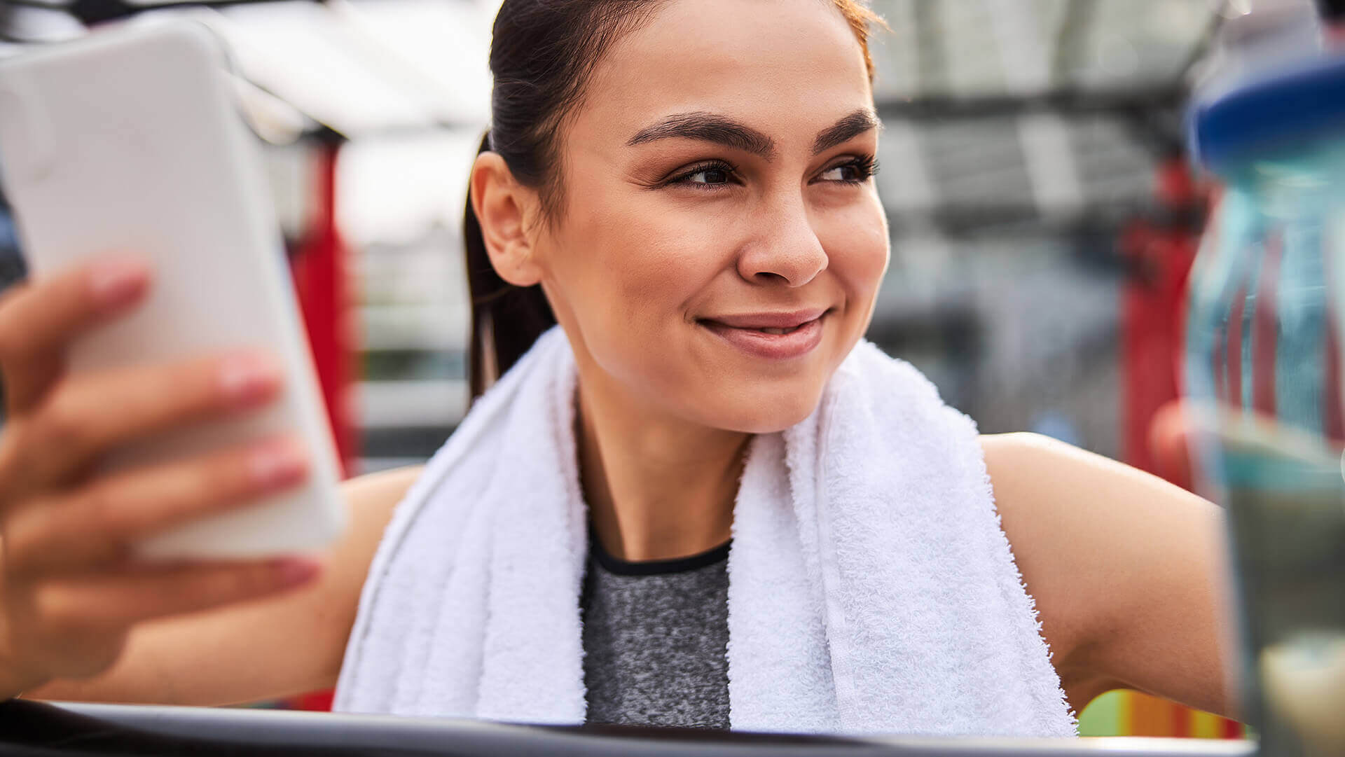 Młoda kobieta korzystająca z telefonu podczas biegania