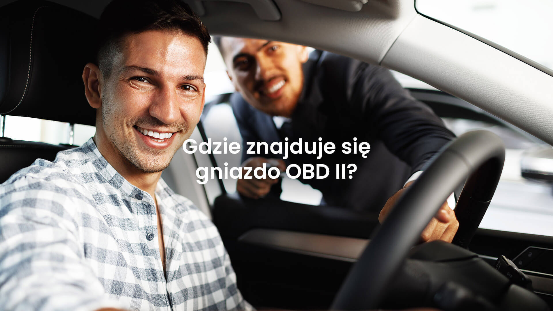 Mężczyzna w aucie wskazujący gniazdo OBDII