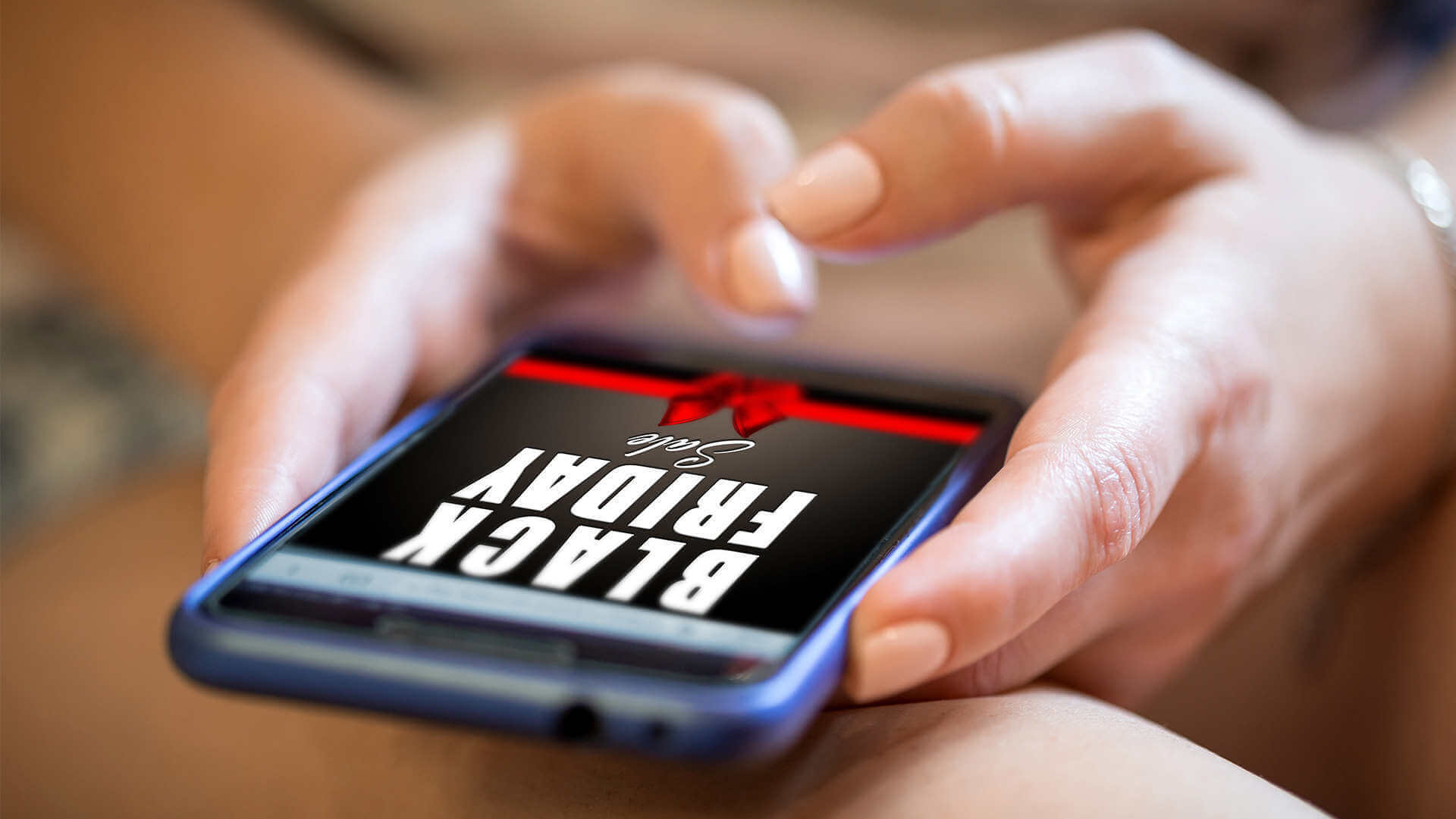 Mężczyzna trzymający w dłoniach telefon komórkowy ze screenem okazji Black friday