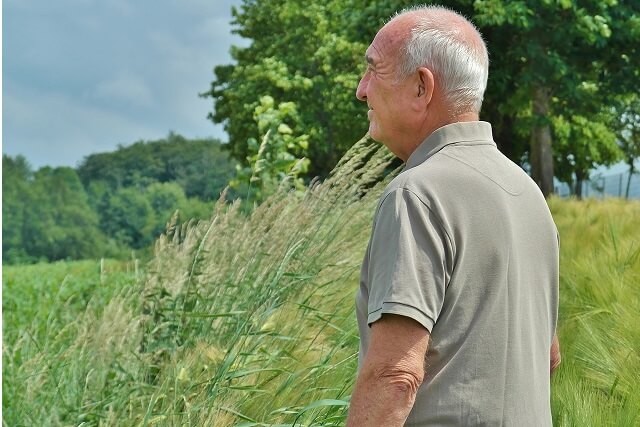 Senior, który ma problemy z pamięcią patrzący na horyzont